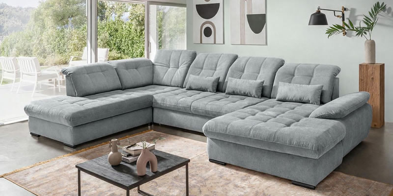 graues-sofa-rigatti-mit-einer-pastellgruenen-wand-in-einem-modernen-ambiente