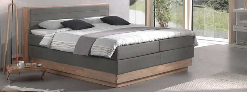 boxspringbett in der farbe grau mit holzumrandung