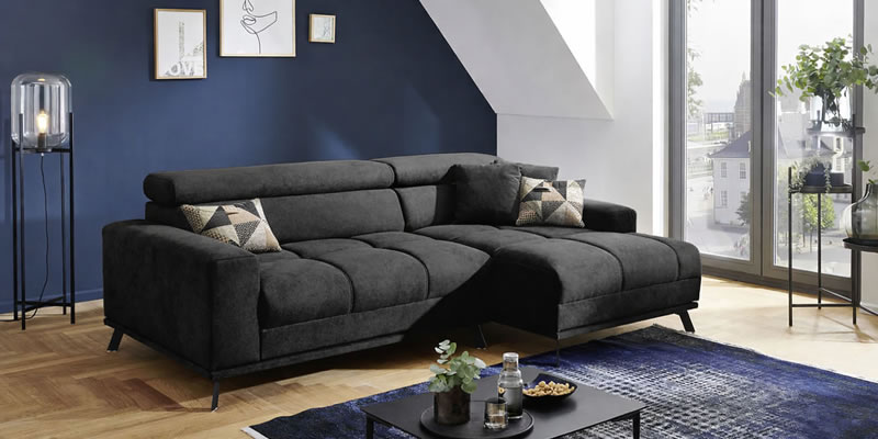 schwarzes-ecksofa-malte-mit-dunkelblauem-teppich-und-gemusterten-kissen