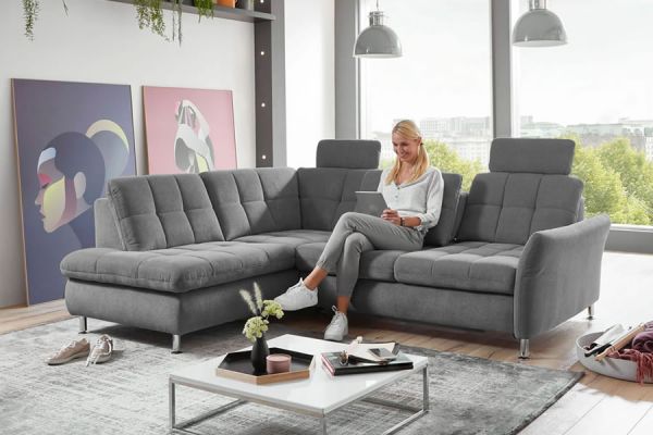 frau-sitzt-auf-einem-grauen-sofa-in-aufrechter-sitzposition
